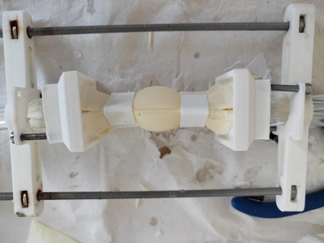 Latex heart chambers mounted between 3D-printed holders on a tensioning frame