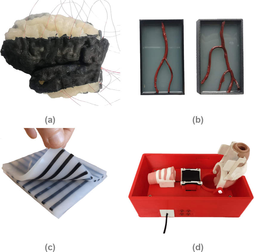 Four applications of the carbon black silicone composite: a brain phantom with a black sensory surface and wires, two artificial blood vessels in boxes, a silicone sheet with a grid of black strain sensors, and a red larynx simulator box with a sensor mat